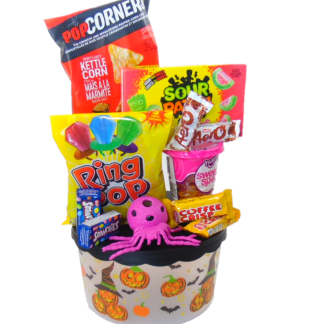 Halloween Gift Basket Treats Box.  Gift box with lid filled with snacks and treats for Halloween Day. Clear round 8 inches gift box with orange pumpkin printed theme and black lid. Halloween sweets siting inside box gift basket with ribbon and gift message. Halloween gift basket treat box is the best gift to send both adults and kids to enjoy on Halloween Day.  